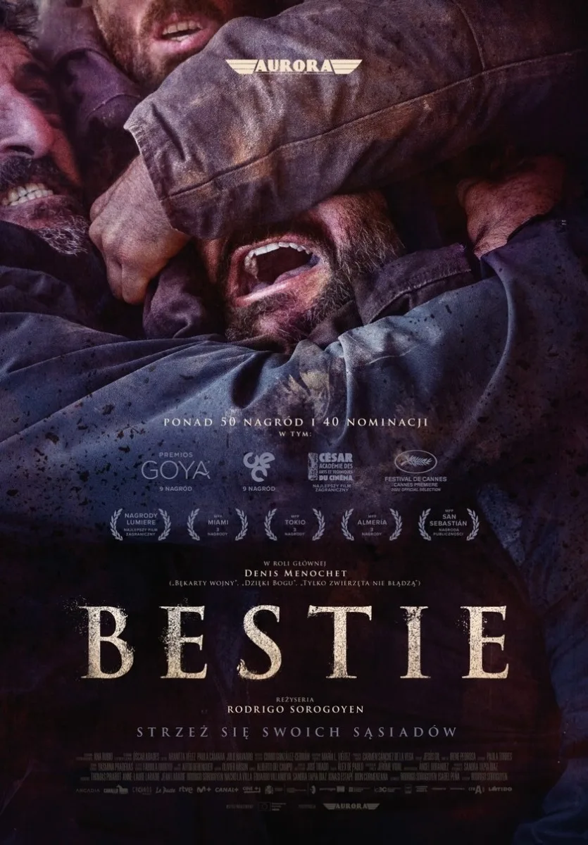 Plakat promujący film BESTIE. Widać fragment niebieskiej koszulki i otwarte z wysiłku usta trzech mężczyzn, obejmujących się w walce.